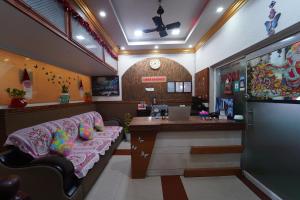 a waiting area of a salon with a couch and a desk at LlBRA REGENCY in Guruvāyūr
