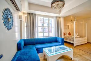 a living room with a blue couch and a bed at Casa Pajaros in Calangute +24 photos