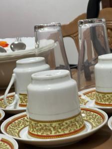 a group of cups and plates on a table at UK Villa & Guest house in Jaffna