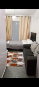 a bedroom with a bed and a couch and a rug at Tembea Stays in Kiambaa