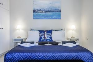 a bedroom with a blue bed with two lamps at Andromachi's house in Loutraki