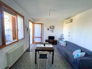 a living room with a blue couch and a table at Casa Ariel in Lido Adriano
