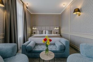 a hotel room with a bed and a vase of flowers on a table at King Gorgasali in Tbilisi City
