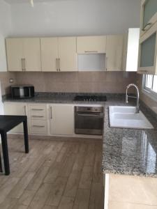 a kitchen with white cabinets and a sink at Casa hersi in Hennchir Ksar Rhaleb
