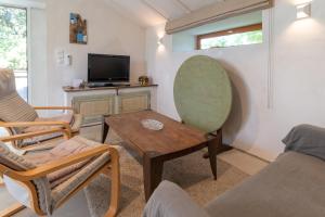 a living room with a table and chairs and a tv at La Terrasse in Patrimonio
