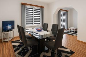 a dining room with a glass table and chairs at Cazin Centar Ćuprija in Cazin
