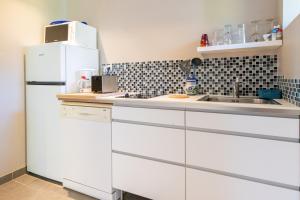 a kitchen with a white refrigerator and a sink at Le Studio - Ancienne Cave in Patrimonio