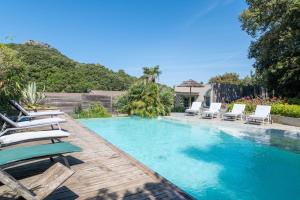 a swimming pool with chaise lounge chairs and a resort at La Terrasse in Patrimonio