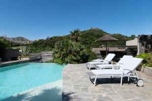 a group of chairs sitting next to a swimming pool at La Terrasse in Patrimonio
