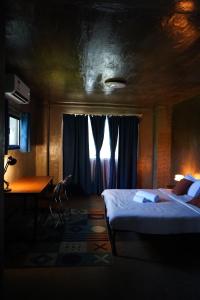 a bedroom with a bed and a desk and a window at yolked suites in General Luna +6 photos