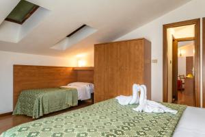 a hotel room with two beds with towels at Hotel Oasi Verde in Lido di Jesolo