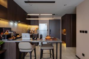 a kitchen with a table with chairs and a refrigerator at The Panora Estuaria Pattaya in Na Jomtien