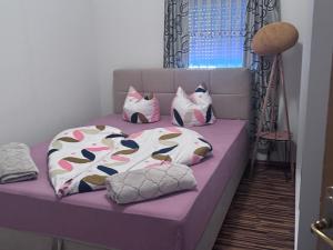a purple bed with pillows on top of it at Cazin Centar Ćuprija in Cazin