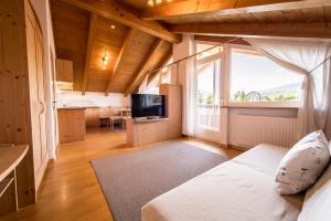 a living room with a bed and a large window at Residence Walder in Falzes