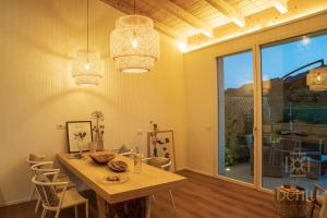 a dining room with a table and a large window at Bentu Boutique Apartment in San Nicolò Gerrei