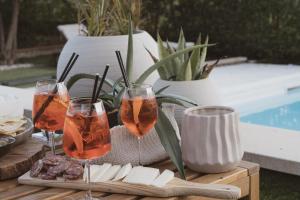 a table with three wine glasses and cheese at Bentu Boutique Apartment in San Nicolò Gerrei +79 photos