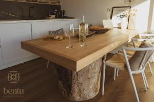 a wooden table with wine glasses on top of it at Bentu Boutique Apartment in San Nicolò Gerrei