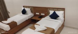 a room with two beds and a phone in it at hotel ananth inn in Mahālingpur