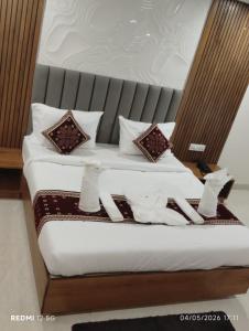 a bed with brown and white sheets and pillows at hotel ananth inn in Mahālingpur