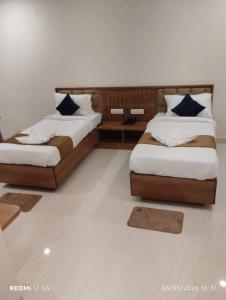 two beds in a room with two pillows at hotel ananth inn in Mahālingpur