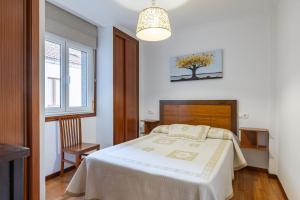 a bedroom with a bed and a tree on the wall at Apartamento Río do Con Vilagarcía in Vilagarcia de Arousa