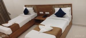 a room with two beds and a table with a phone at hotel ananth inn in Mahālingpur +10 photos