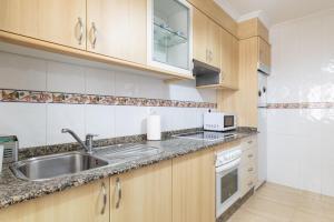 a kitchen with a sink and a microwave at Apartamento Río do Con Vilagarcía in Vilagarcia de Arousa