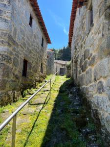 an alley between two stone buildings next to a wall at Dão country house in Silgueiros