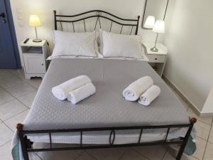 ein Bett mit zwei zusammengerollten Handtüchern darauf in der Unterkunft Captain's Nest in Ándros + 16 Fotos