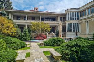 a large building with a garden in front of it at Le Blanc Cotroceni Hotel in Bucharest
