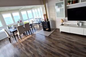 a living room with a dining table and a tv at Playa Catedrales Village in Barreiros