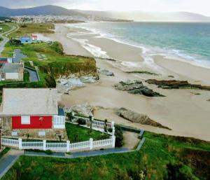 an aerial view of a red house and the beach at Playa Catedrales Village in Barreiros