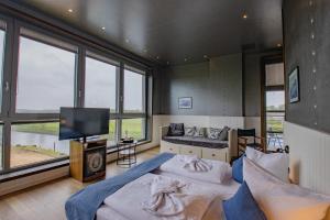a bedroom with two beds and a flat screen tv at Hotel Dömitzer Hafen in Dömitz
