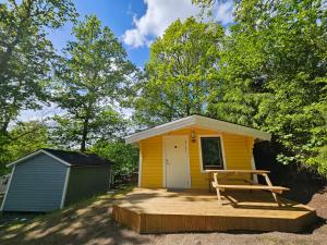 a small yellow shed with a picnic table in front of it at Lygnareds Camping in Alingsås