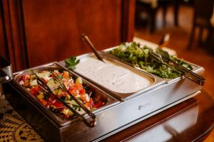 two trays of food on a table with chopsticks at Hotel Elenka in Veľký Meder