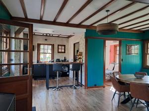 a kitchen and dining room with green walls and a table at Le rêve au fil de l'eau in Marmagne