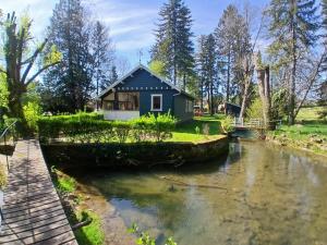 a house next to a river with a bridge at Le rêve au fil de l'eau in Marmagne