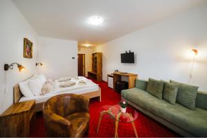 a living room with a couch and a bed at Hotel Elenka in Veľký Meder