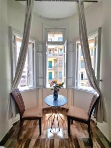 a room with two chairs and a table and two windows at Qasr court in Cairo