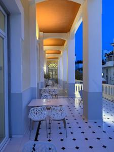 a patio with chairs and a table on a balcony at Tinion Hotel in Tinos