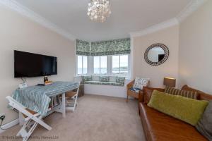 a living room with a couch and a table and a television at Bass Rock View in North Berwick