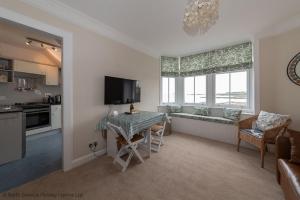 a living room with a table and a kitchen at Bass Rock View in North Berwick +17 photos