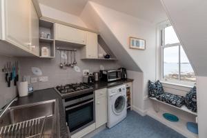 a kitchen with a sink and a washing machine at Bass Rock View in North Berwick