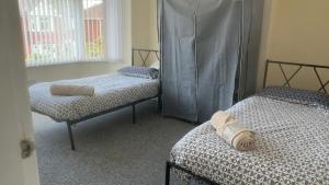 a room with two twin beds and a window at Cosy 3 Bed house with garden 5 min walk from Doncaster Racecourse in Doncaster