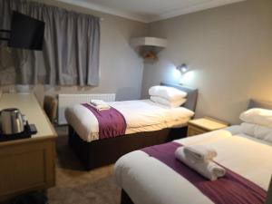 a hotel room with two beds and a desk at The Paddington House in Warrington
