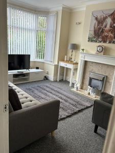 a living room with a couch and a fireplace at Cosy 3 Bed house with garden 5 min walk from Doncaster Racecourse in Doncaster