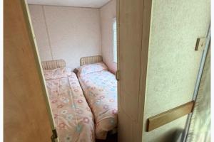 a small bedroom with a bed in a small room at Static Caravan Sleeps 8 with Indoor Pool in Clacton-on-Sea +14 photos