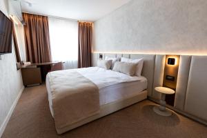 ein Schlafzimmer mit einem großen weißen Bett und einem Fenster in der Unterkunft Civico14 in Târgovişte