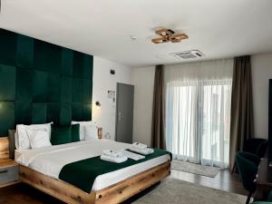 a bedroom with a large bed with a green headboard at Hotel B4 in Oradea +131 photos