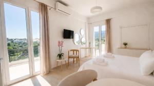 a white living room with a large window at Orama Studios in Plakias